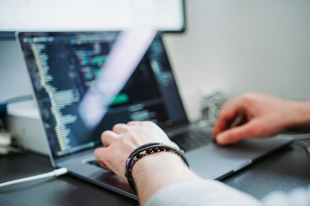 programmer coding on laptop